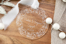 Load image into Gallery viewer, Clear acrylic round engagement ornament on engraved with names and engagement date with thick floral wreath. Displayed on a wooden tray.
