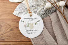 Load image into Gallery viewer, Round Merry Christmas Auntie ornament with personalization of last name and due year on a wooden surface with decorative elements.