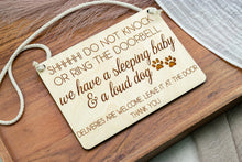 Load image into Gallery viewer, Angled view of a rectangular wooden door sign with rounded corners, sleeping baby and loud dog message, and paw prints.