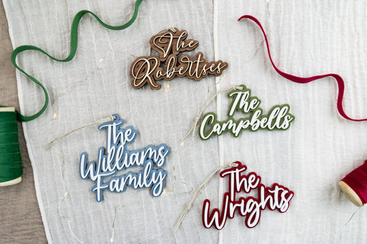 Four personalized family name ornament examples showing different lettering styles and acrylic color combinations.