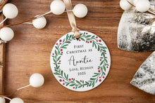 Load image into Gallery viewer, Personalized Christmas ornament with 'First Christmas as Auntie' text, surrounded by decorations on a wood background.
