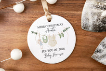 Load image into Gallery viewer, Round Merry Christmas Auntie ornament with personalization of last name and due year on a wooden surface with decorative elements.
