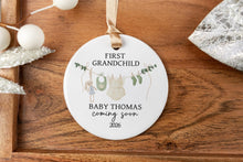 Load image into Gallery viewer, Personalized ceramic ornament for first girl grandchild. Personalized with the baby's last name and due year on a wooden tray with decorative elements.
