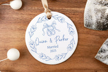 Load image into Gallery viewer, Round christmas ornament with 'names Married 2025' text on a wooden surface.
