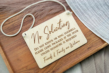 Load image into Gallery viewer, Angled view of a rectangular birch wood door sign engraved with No Soliciting, delivery instructions, and Friends &amp; Family are Welcome.
