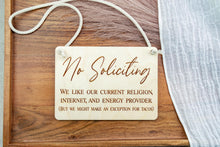 Load image into Gallery viewer, Angled view of a rectangular engraved wooden No Soliciting sign with white cotton rope hanger.
