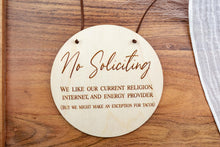 Load image into Gallery viewer, Round birch wood No Soliciting sign engraved with a humorous message about religion, internet, energy providers, and tacos.
