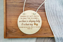 Load image into Gallery viewer, Natural birch wood door sign with engraved sleeping baby and loud dog message, shown hanging by cotton rope.
