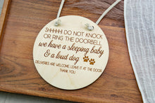 Load image into Gallery viewer, Round wooden do not knock sign with a white cotton rope hanger and engraved lettering.
