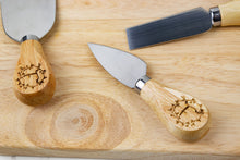 Load image into Gallery viewer, cheese knives with letter f and wreath detail on a cutting board
